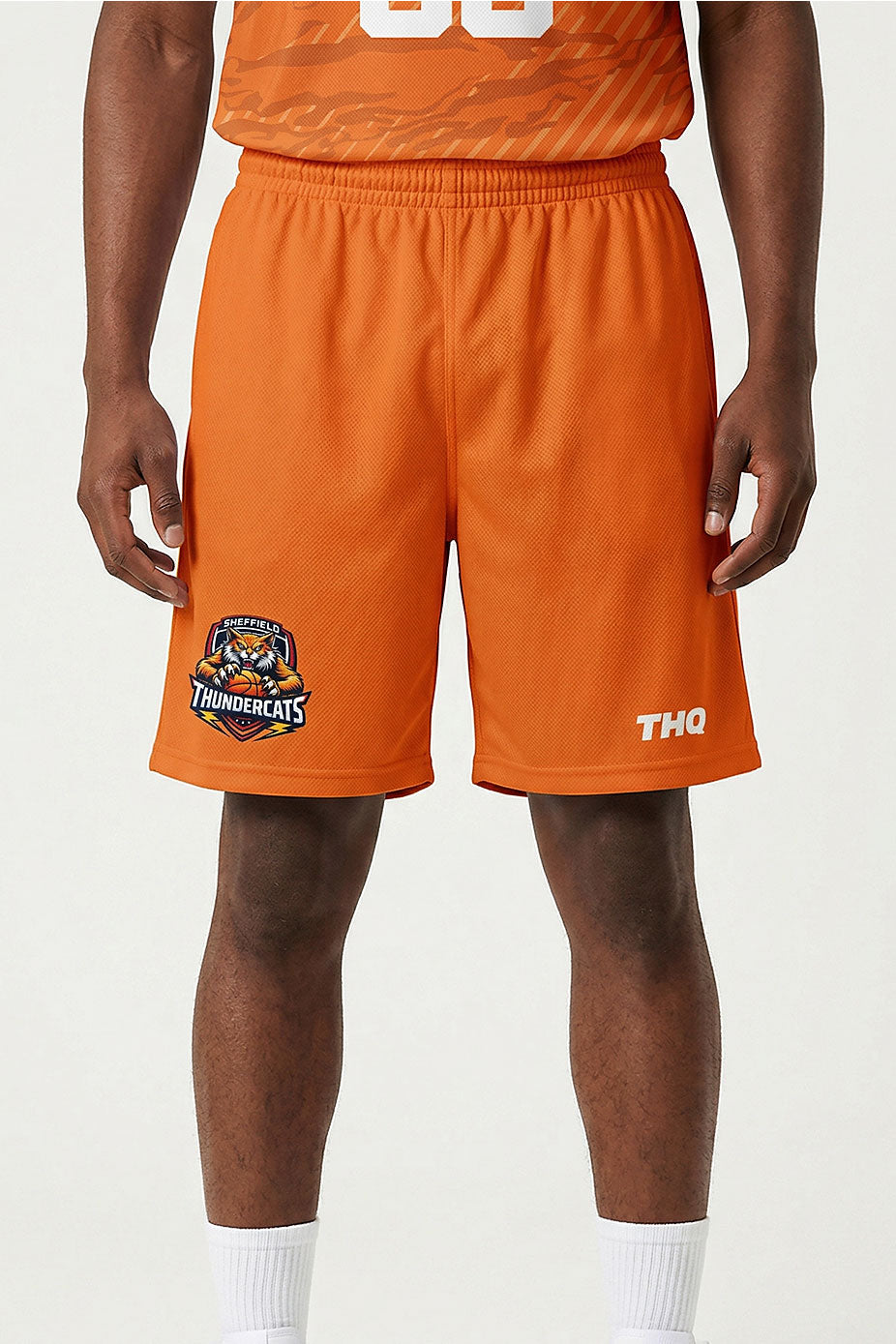 Athlete wearing an Orange sublimated shorts with a logo THQ logo and Thundercats logo on a white background