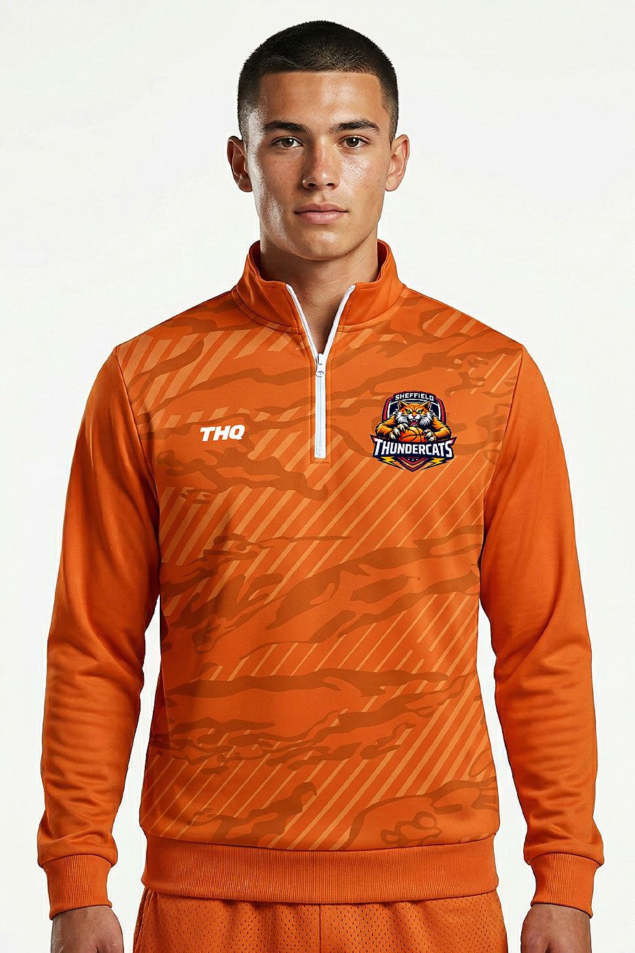 Athlete wearing Orange sublimated quarter ziptop with THQ logo and Thundercats logo. 