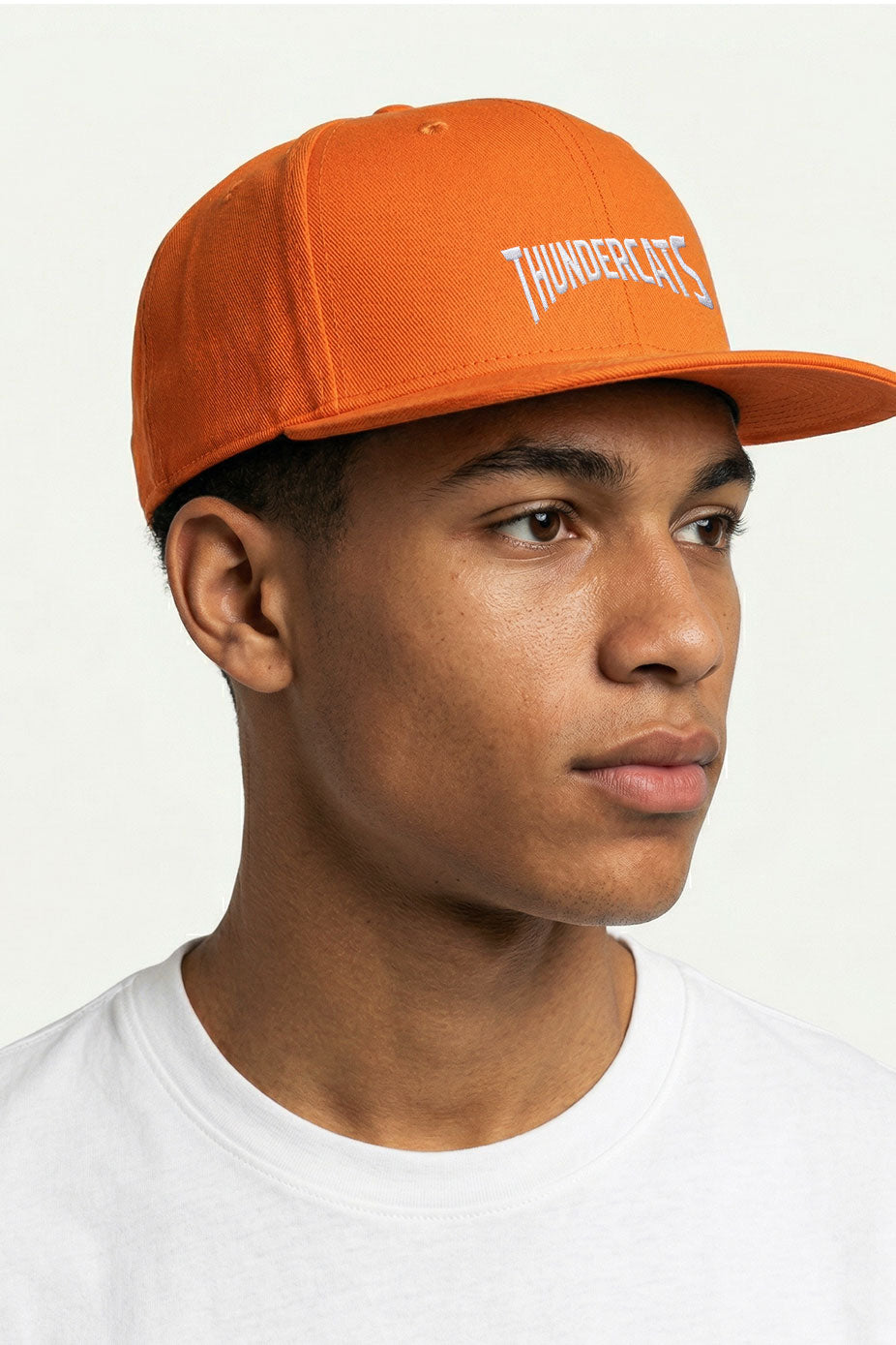 An athlete wearing an Orange Snapback hat with embroidery.